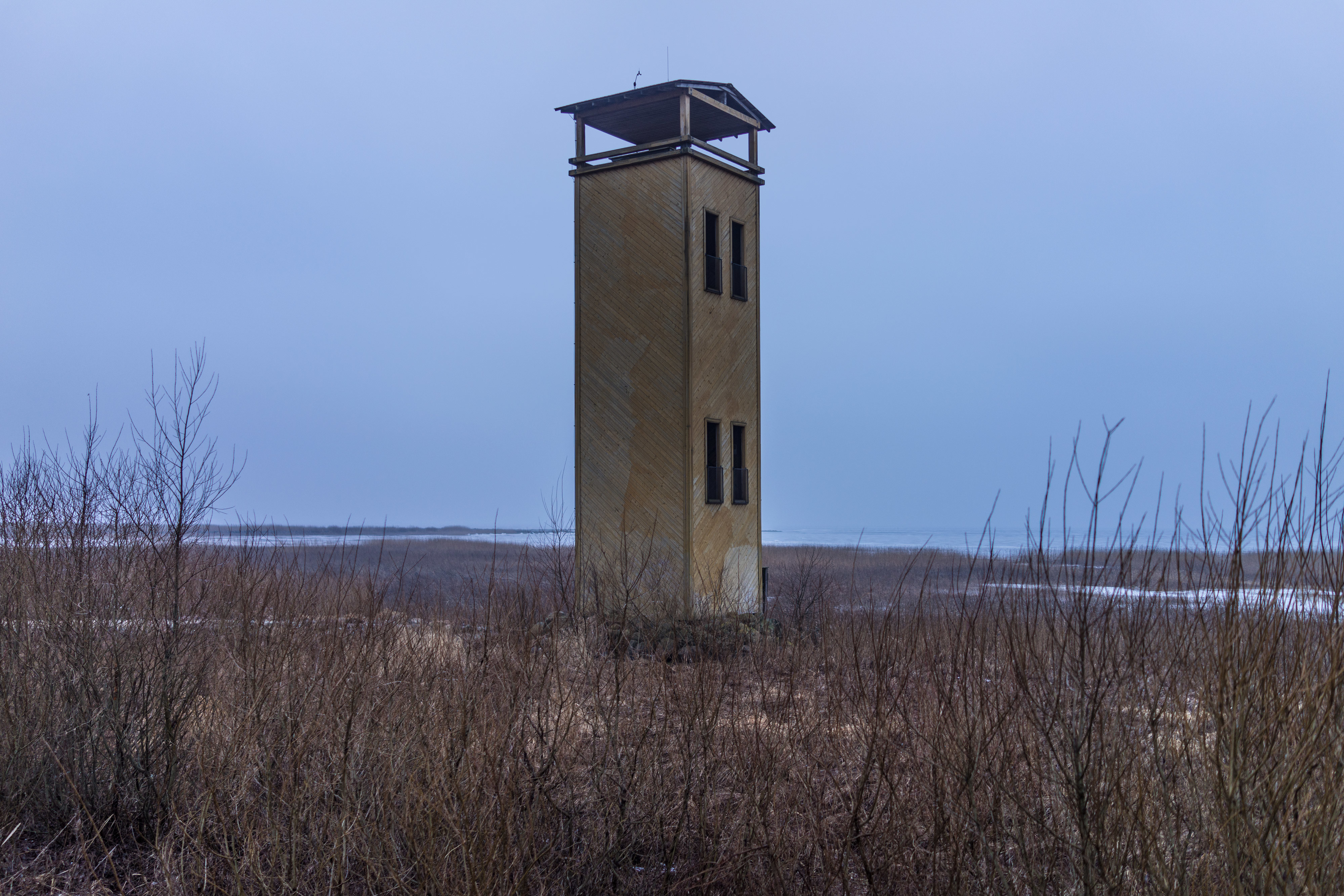 A lookout tower on the northern shore of Võrtsjärv. The miniature house-like buildings in lifeless landscapes add a layer of additional emptiness to the already deserted winterscape. The warmth pours into you by just standing and watching this silence.