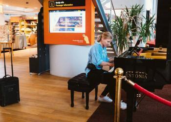 A passenger playing a piano at Tallinn Airport.