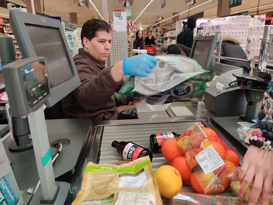 At the grocery store, people have to keep a distance and only a certain number of people are allowed in. The cashier is wearing rubber gloves and is spraying them with something constantly. Photo by Silver Meikar.