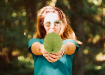 A woman holding a green leaf. Photo by Mert Guller on Unsplash.