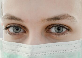 A woman wearing a disposable face mask. The image is illustrative. Photo by Ani Kolleshi/Unsplash.