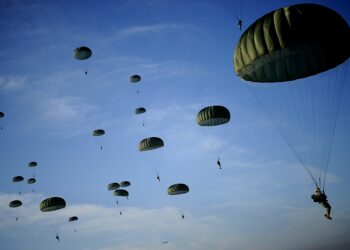 Soldiers with the 82nd Airborne Division descend under a parachute canopy to earn foreign jump wings during the 11th Annual Randy Oler Memorial Operation Toy Drop at Fort Bragg, North Carolina. Photo by US Air Force (Public Domain).