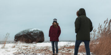 A woman and a man keeping a politely Estonian distance by the sea. Photo by Renee Altrov.