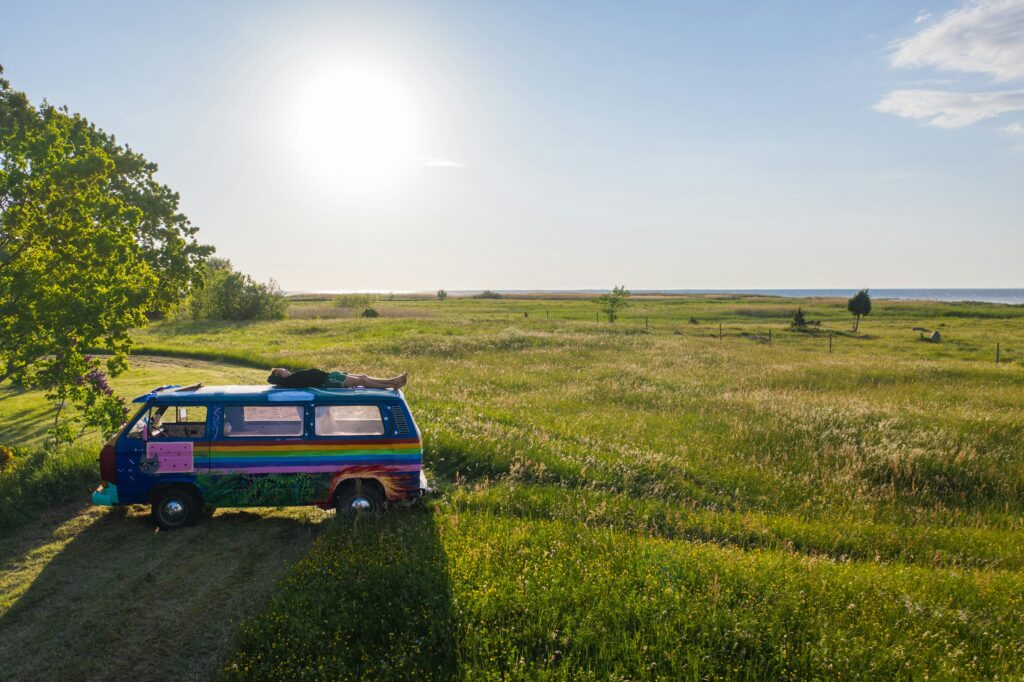 A hippy boy sleeping on top of a van in Kihnu island, Estonia. Photo by Geio Tischler on Unsplash.