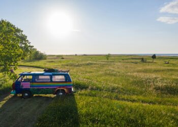 A hippy boy sleeping on top of a van in Kihnu island, Estonia. Photo by Geio Tischler on Unsplash.