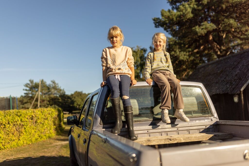 Two girls sitting on a car roof in Estonia. In many areas of the country, the car is an absolute necessity, since the public transport is not efficient enough. Photo by Renee Altrov.