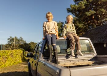 Two girls sitting on a car roof in Estonia. In many areas of the country, the car is an absolute necessity, since the public transport is not efficient enough. Photo by Renee Altrov.