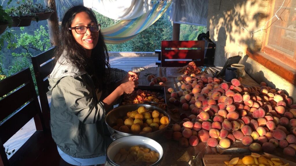 Sara Singh somewhere in the mountains of India, peeling peaches to make jam. Private collection.