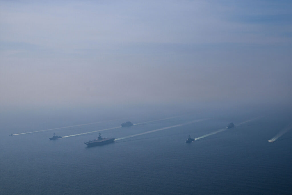 Carrier Strike Group 3 sails in formation in the Arabian Sea during the US military build-up in the Middle East, 6 February 2026. Public domain.