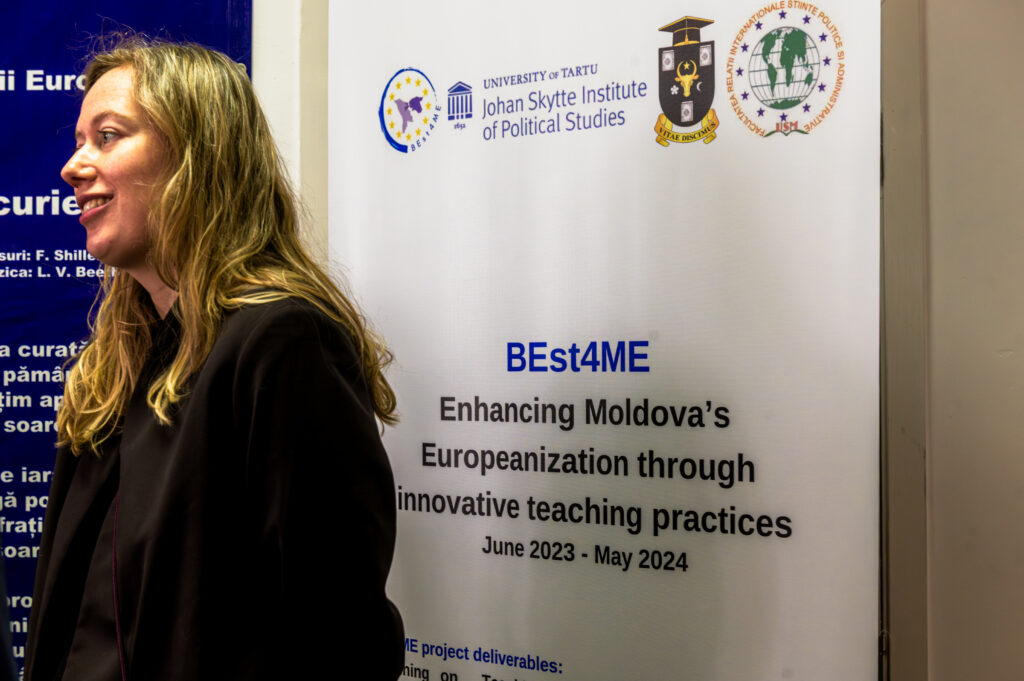 A speaker at the event stands beside information about a University of Tartu-led project aimed at strengthening Moldova’s European readiness through innovative teaching. Photo by Iurie Gandrabura.