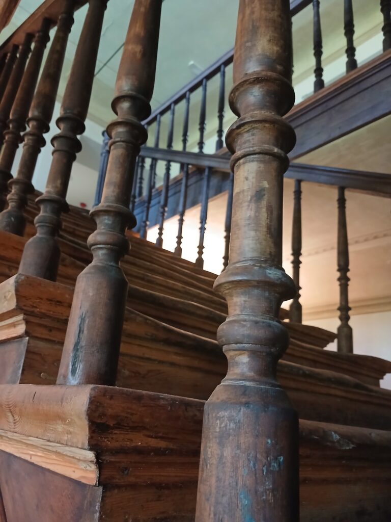 The wooden staircase inside Anija Manor – the kind of place where every creak seems to arrive with a story. Photo by Anija Manor.