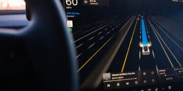 A Tesla’s driver assistance display showing the car monitoring surrounding lanes while in self-driving mode. Photo by Josh Sorenson on Unsplash.