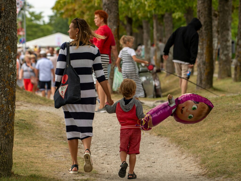 A mother and child walk through a lively summer open-air concert in Kuressaare, Estonia.  Photo by Margo Evardson.