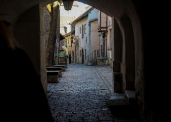 A dark passageway in Tallinn’s Old Town, where ghost stories have echoed for centuries. Photo by Oona Ahonen / Unsplash.