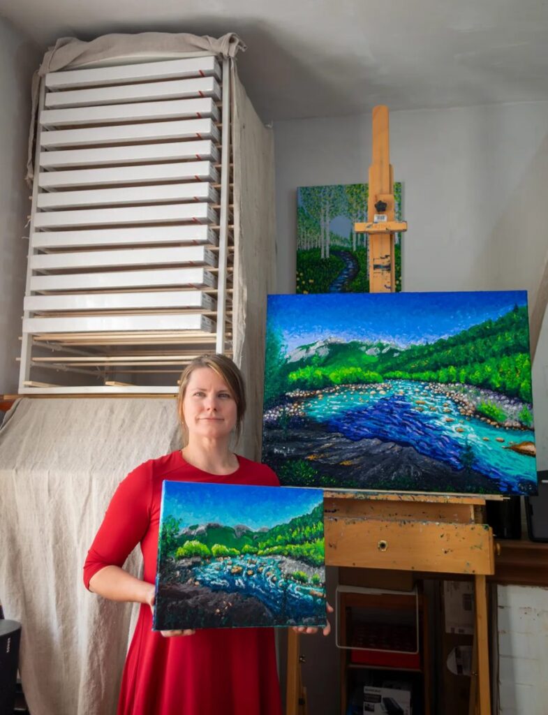 Keili Major in her Garessio studio with two finger-painted landscapes of the Tanaro river. Private collection.