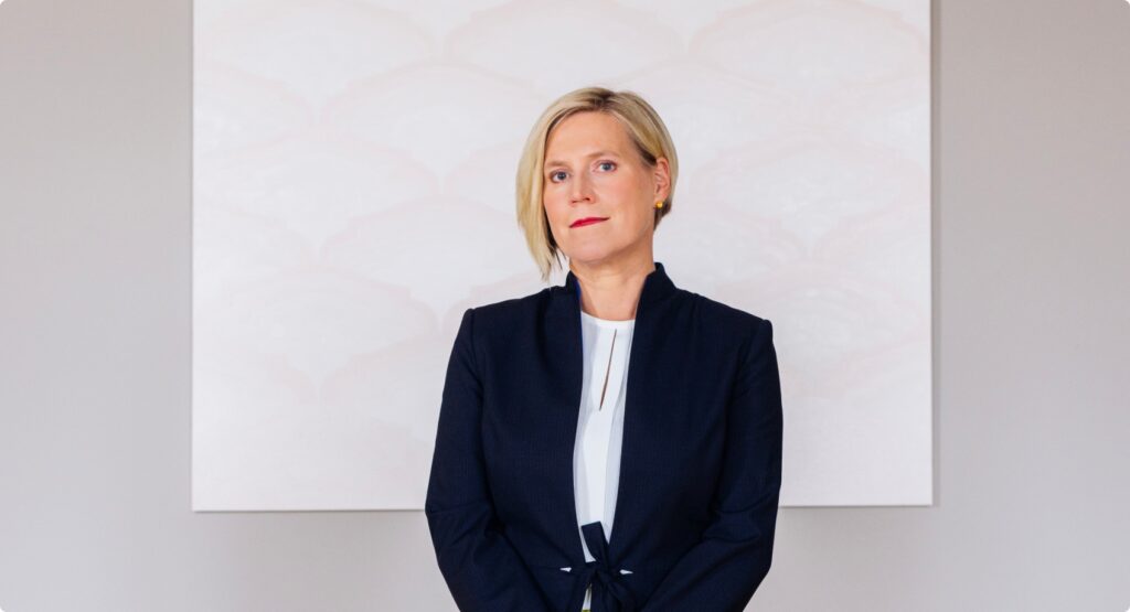 Ülle Madise photographed at the Office of the Chancellor of Justice, in front of the painting "To Write One's Own / Your Name. M4" by Sirja-Liisa Eelma. Photo: the Office of the Chancellor of Justice.