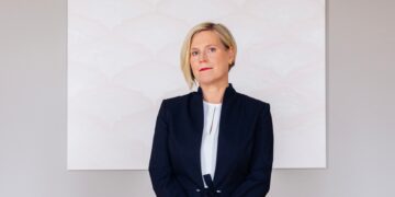 Ülle Madise photographed at the Office of the Chancellor of Justice, in front of the painting "To Write One's Own / Your Name. M4" by Sirja-Liisa Eelma. Photo: the Office of the Chancellor of Justice.